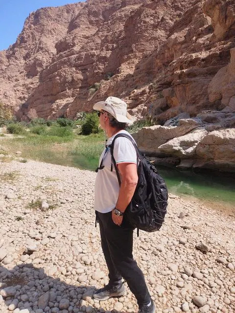 Canyon rocheux et bassin d’eau naturelle, avec des personnes visibles.