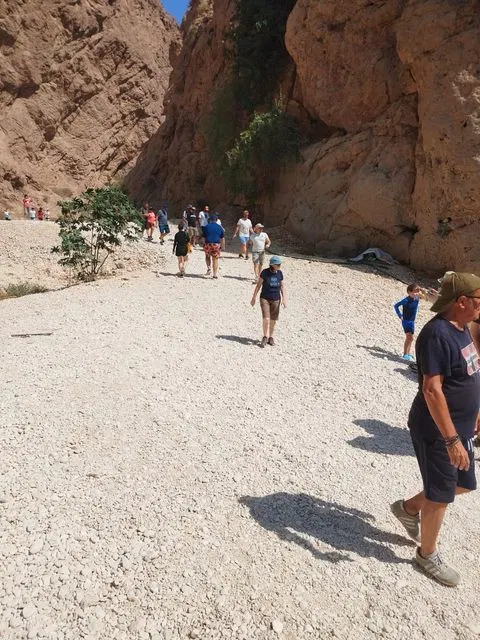 Canyon rocheux et bassin d’eau naturelle, avec des personnes visibles.