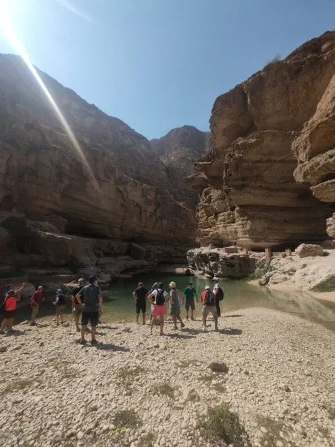 Canyon rocheux et bassin d’eau naturelle, avec des personnes visibles.