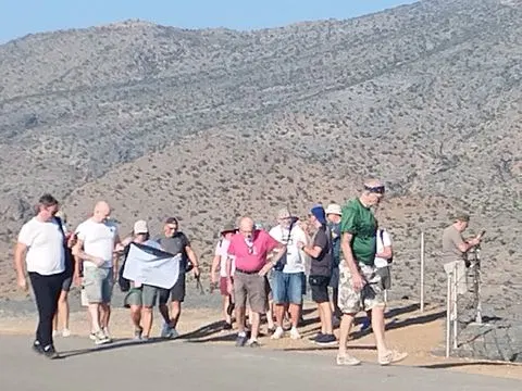 Paysage côtier avec plage et bateaux, avec des personnes visibles.