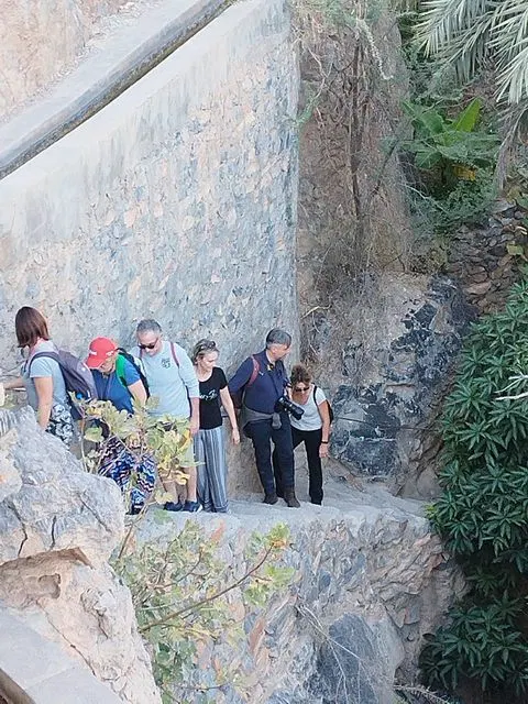 Canyon rocheux et bassin d’eau naturelle, avec des personnes visibles.