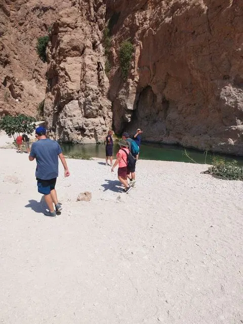 Canyon rocheux et bassin d’eau naturelle, avec des personnes visibles.