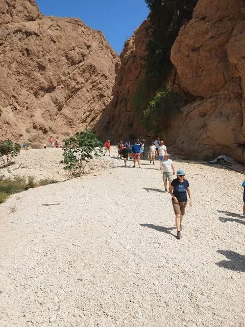 Canyon rocheux et bassin d’eau naturelle, avec des personnes visibles.