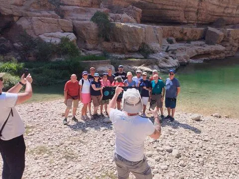 Canyon rocheux et bassin d’eau naturelle, avec des personnes visibles.
