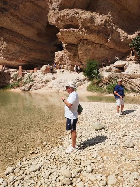 Canyon rocheux et bassin d’eau naturelle, avec des personnes visibles.