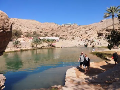 Canyon rocheux et bassin d’eau naturelle, avec des personnes visibles.