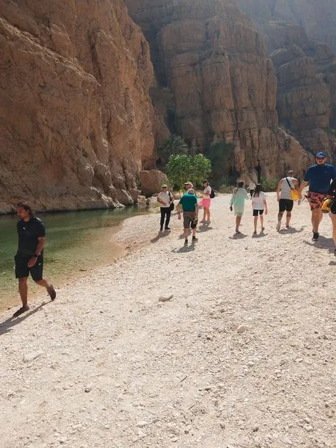 Canyon rocheux et bassin d’eau naturelle, avec des personnes visibles.