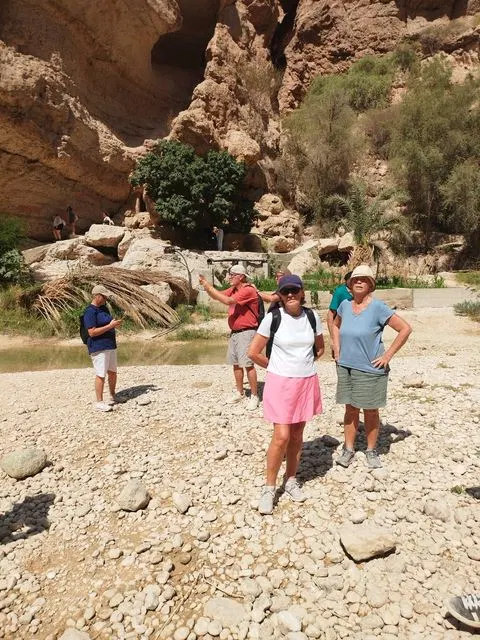 Canyon rocheux et bassin d’eau naturelle, avec des personnes visibles.