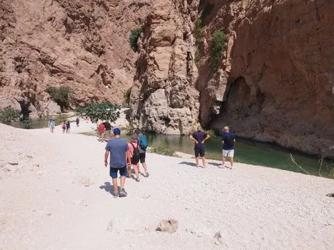 Canyon rocheux et bassin d’eau naturelle, avec des personnes visibles.
