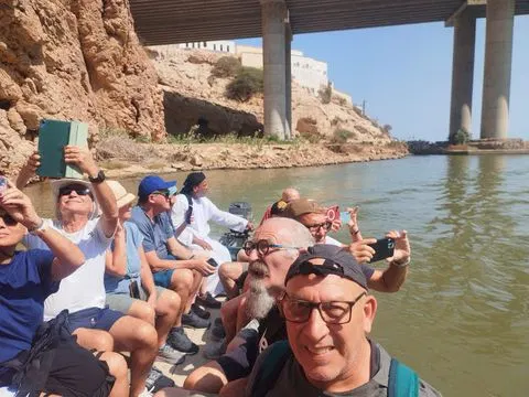 Canyon rocheux et bassin d’eau naturelle, avec des personnes visibles.