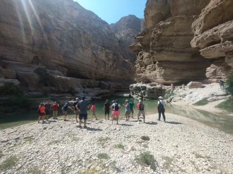 Canyon rocheux et bassin d’eau naturelle, avec des personnes visibles.