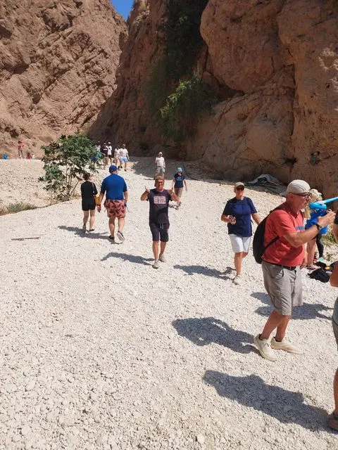 Canyon rocheux et bassin d’eau naturelle, avec des personnes visibles.