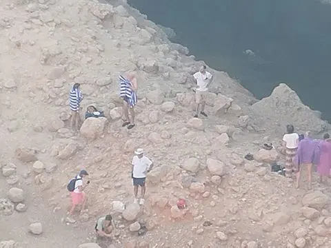 Canyon rocheux et bassin d’eau naturelle, avec des personnes visibles.