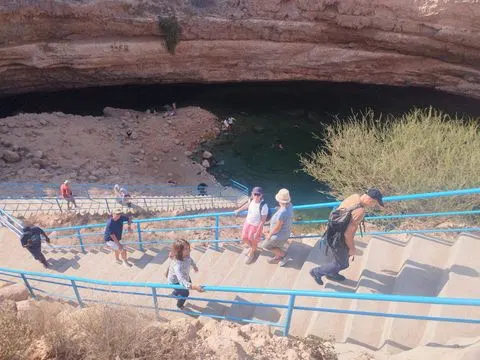 Canyon rocheux et bassin d’eau naturelle, avec des personnes visibles.