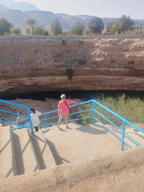 Canyon rocheux et bassin d’eau naturelle, avec des personnes visibles.