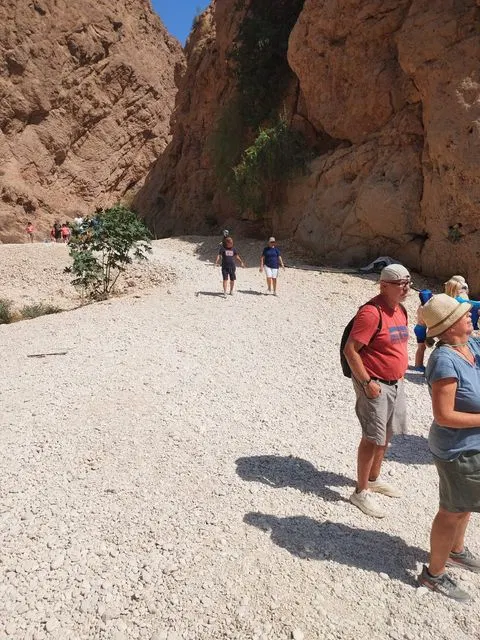 Canyon rocheux et bassin d’eau naturelle, avec des personnes visibles.