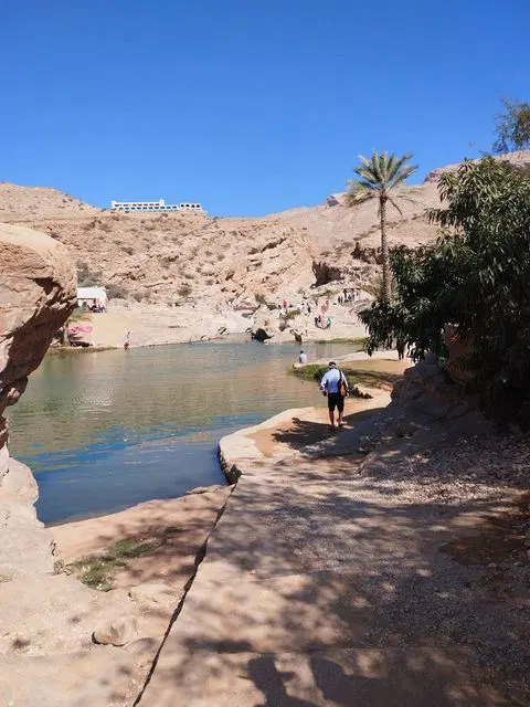 Canyon rocheux et bassin d’eau naturelle, avec des personnes visibles.