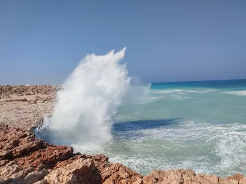 Paysage côtier avec plage et bateaux.