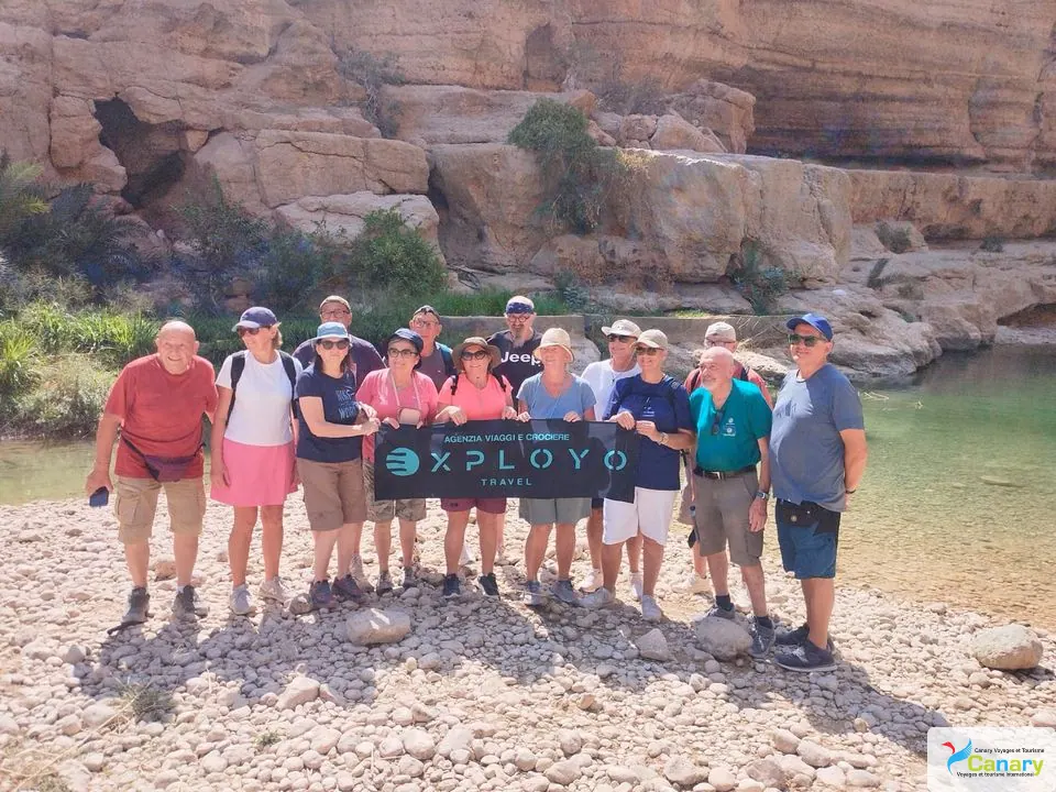 Canyon rocheux et bassin d’eau naturelle, avec des personnes visibles.