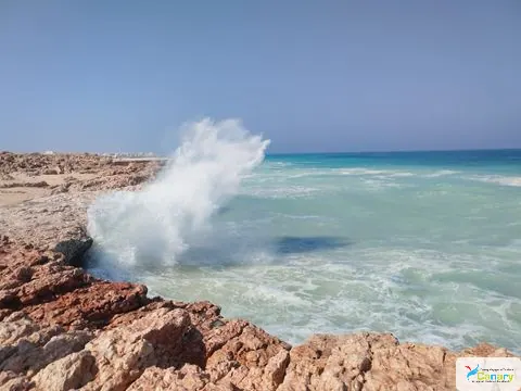 Paysage côtier avec plage et bateaux.