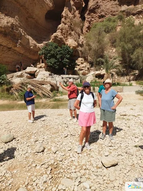 Canyon rocheux et bassin d’eau naturelle, avec des personnes visibles.