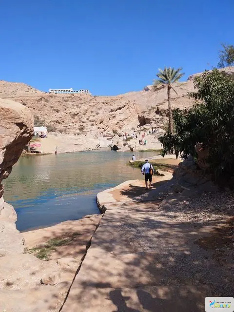 Canyon rocheux et bassin d’eau naturelle, avec des personnes visibles.